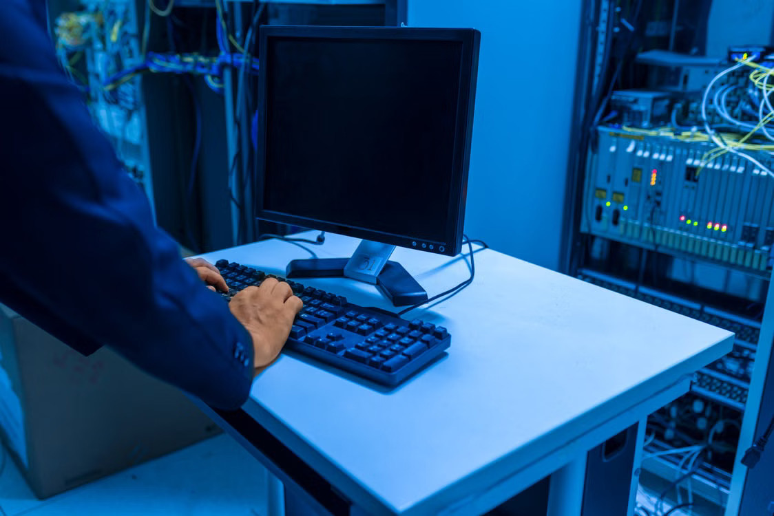 IT technician managing network systems in a server room.