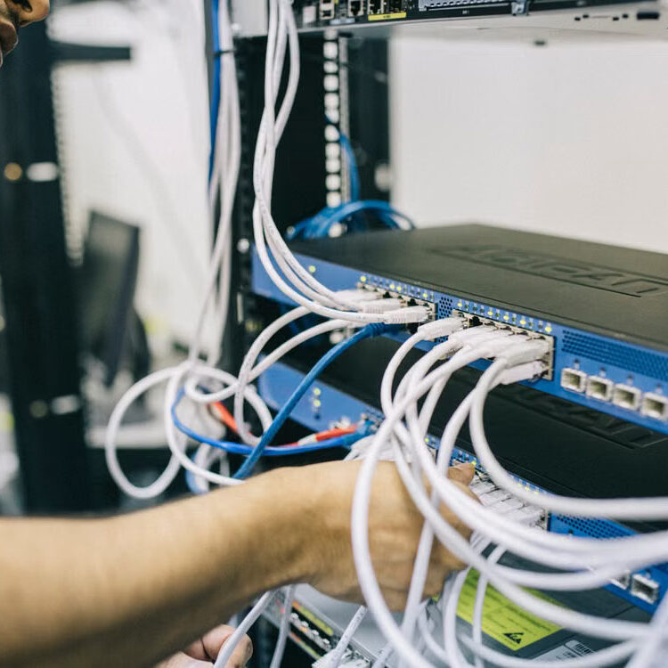 04-protect-network-cabling Technician checking cables inside a server cabinet.