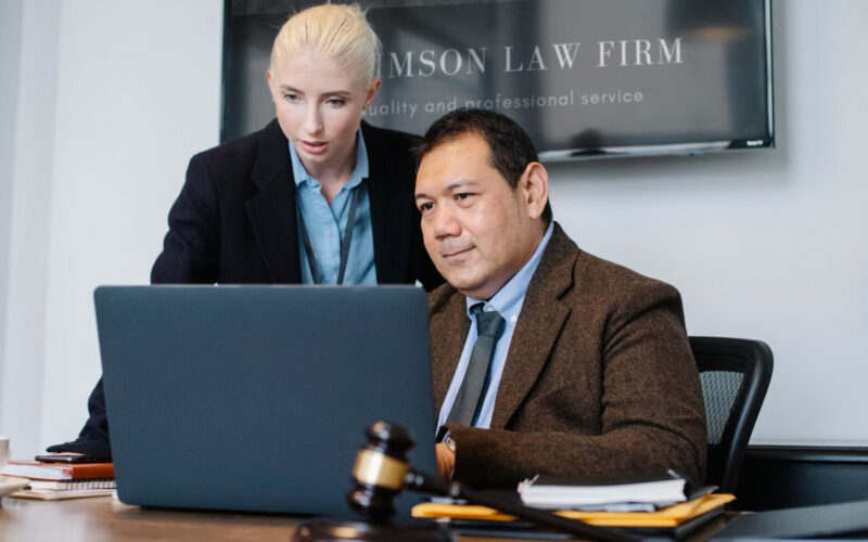 08-law Legal professionals reviewing information together on a laptop.